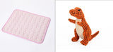 Pink textured mat on the left and a dinosaur plush toy on the right.