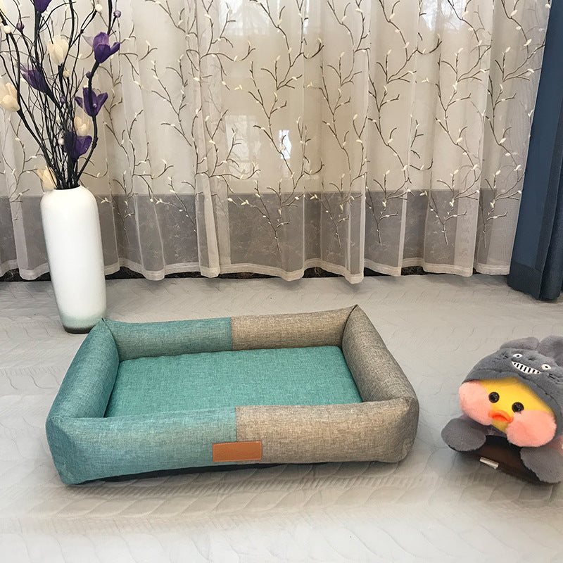 Pet bed with a plush toy on a light-colored floor, with a decorative curtain in the background.