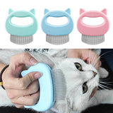 Three pet grooming combs with cat ear handles in blue, green, and pink, with a person using one of them on a cat.