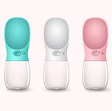 Three pet water bottles in teal, white, and pink on a white background