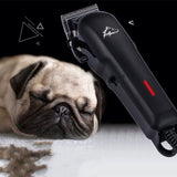Dog grooming clipper next to a sleeping pug on a black background