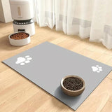 Pet feeding area with a mat, bowls, and a food dispenser on a wooden floor.