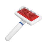 Pet grooming brush with red cushioned area on a white background