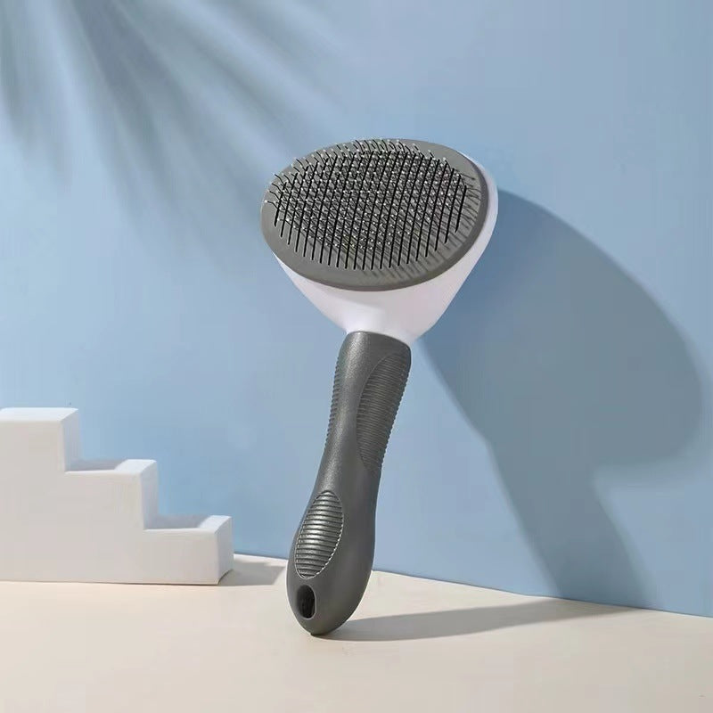 Pet grooming brush with gray bristle side and black handle on a light blue background