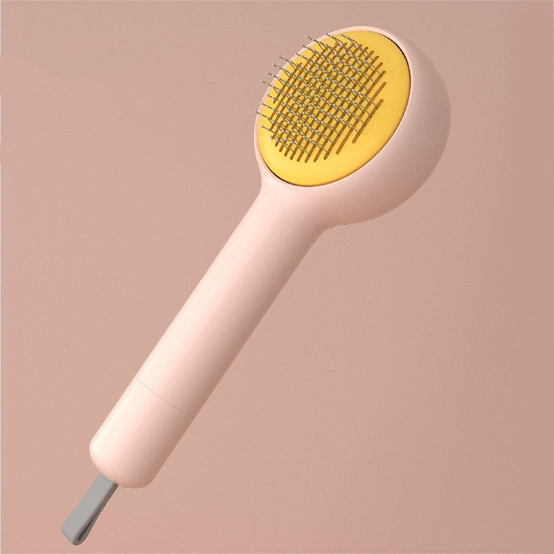 Hairbrush with yellow bristle head and beige handle on a pink background