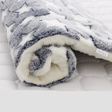Folded gray and white blanket on a white surface