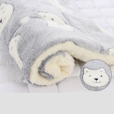 Folded gray and white blanket with a close-up of a polar bear face in the corner.