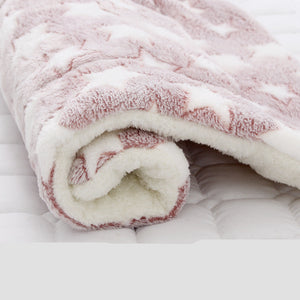 Close-up of a fluffy pink and white blanket on a white surface