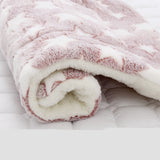 Close-up of a fluffy pink and white blanket on a white surface