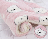 Pink plush blanket with white bear faces on a white background