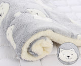 Fluffy gray and white blanket with a close-up of a bear face on a light gray background