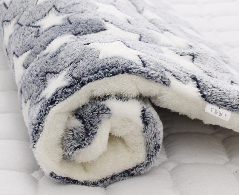 Folded gray and white blanket on a white surface