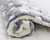 Folded gray and white blanket on a white surface