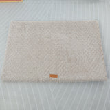 Textured beige rug with a brand label on a transparent background