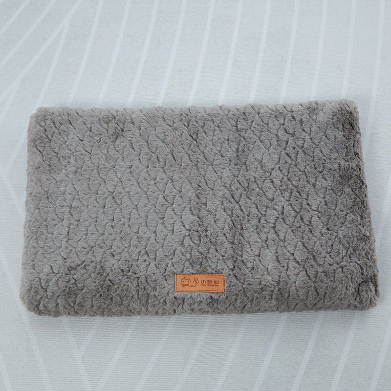 Folded gray textured blanket with a brand label on a white background