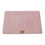 Pink textured blanket with a brand logo on a white background
