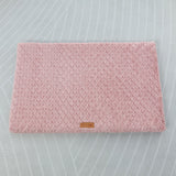 Pink textured mat with a brand logo on a light gray background