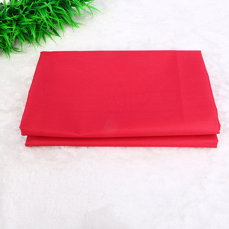 Folded red fabric on a white background with green grass on the side