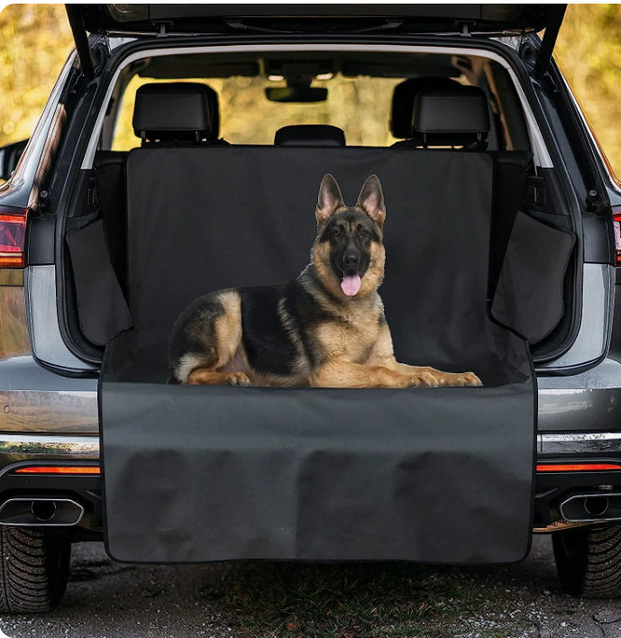 German Shepherd on a car bench cover with open car trunk