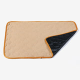 Beige and black quilted saddle pad on a white background