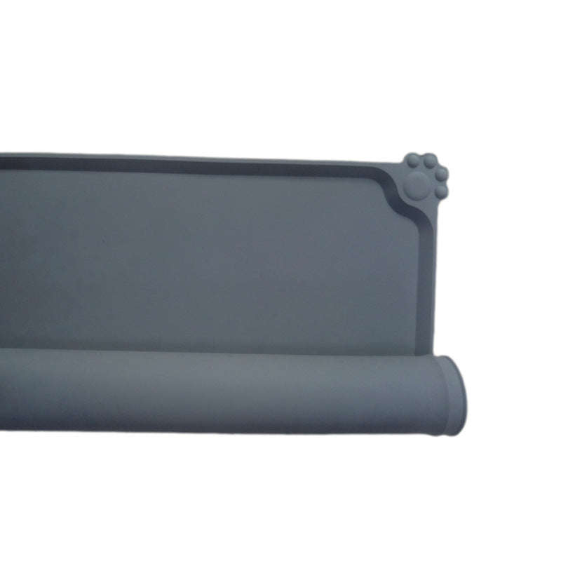 Roll of gray silicone mat with paw print design on a white background